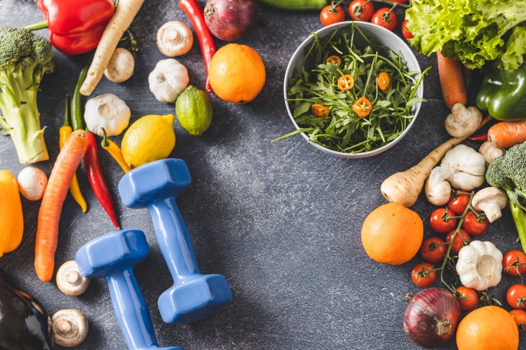 Home female dumbbells and vegetables isolated on dark background